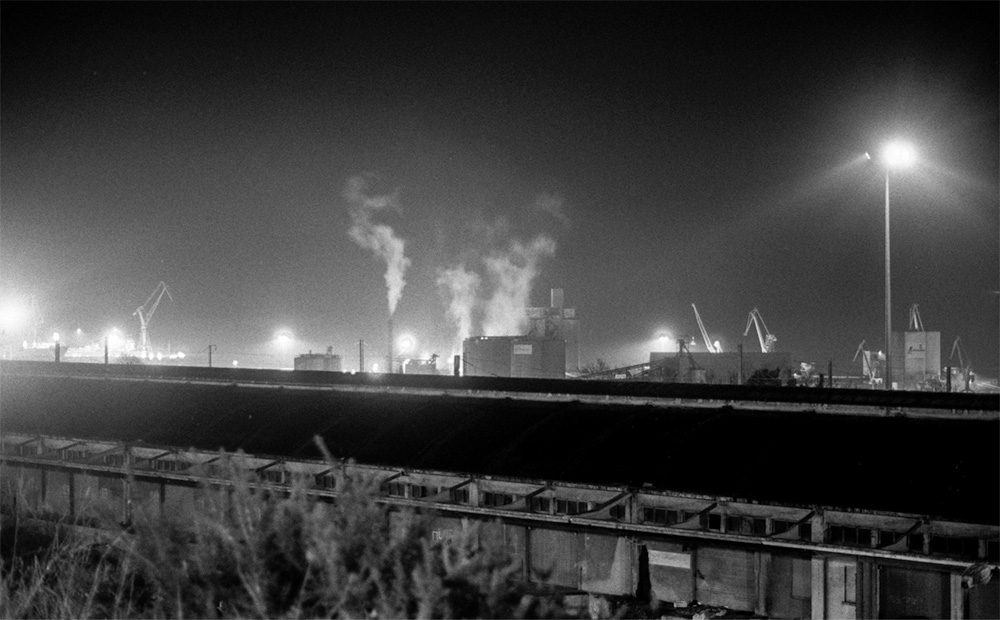 Vue du port de Brest de nuit, des fumée s'envolent dans le ciel